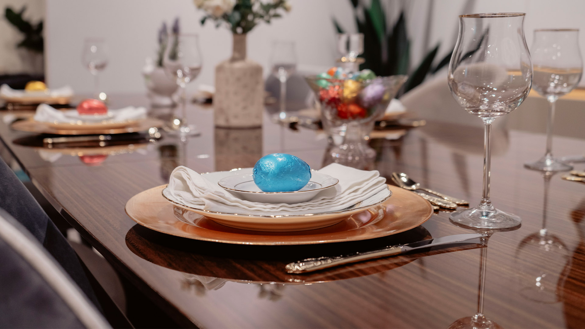 Ovo de Páscoa Azul num Prato em cima de uma Mesa de Jantar de Páscoa